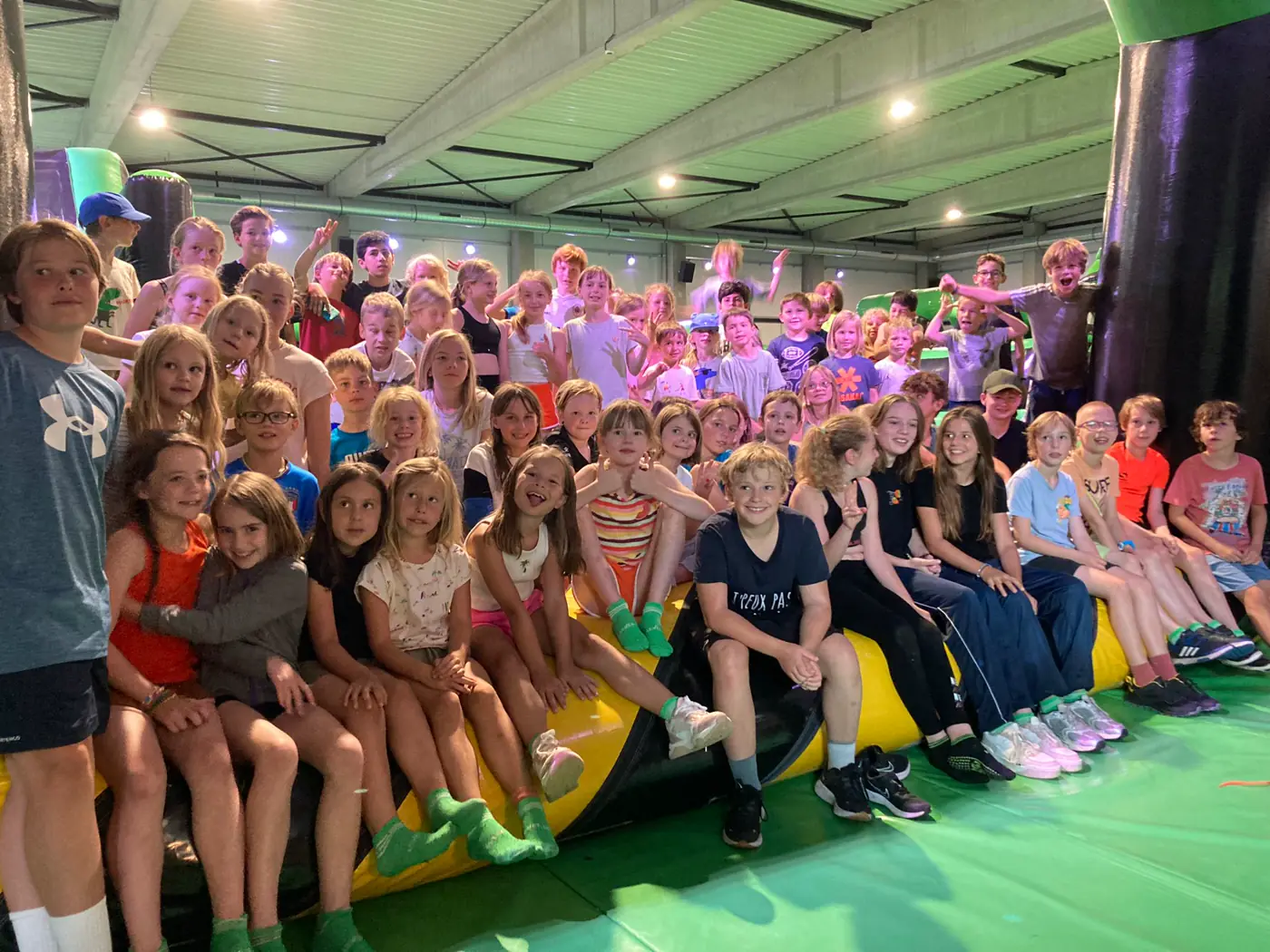 Een grote groep kinderen op het inflatable park tijdens een sportkamp